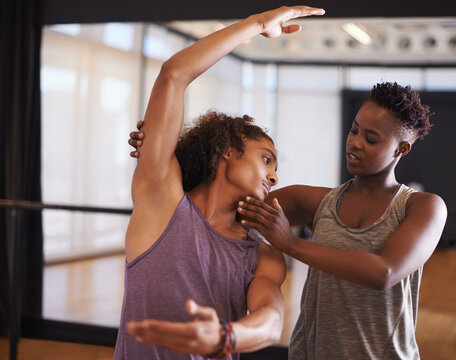 Dancer, instructor and balance for learning, exercise and fitness in a dance studio with form help. Support, teacher and performance workout of man with ballet and wellness in a performing arts class