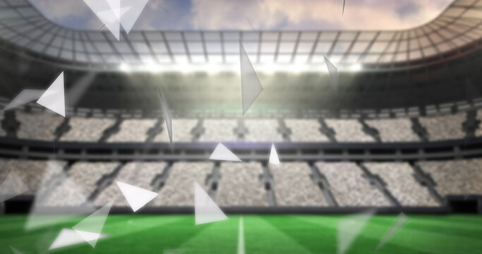 Image of failing shapes and glowing lights over football stadium