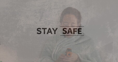 Image of coronavirus slogans over Caucasian woman lying in bed and taking temperature