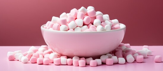 A dish of sugary sweetness, with marshmallows in shades of pink and white resembling petals of a violet plant, resting on a pink table