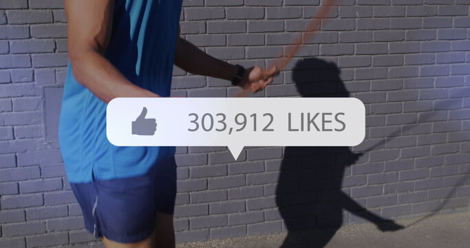 Image of media icons over african american man jumping rope - Powered by Adobe