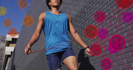 Image of media icons over african american man jumping rope