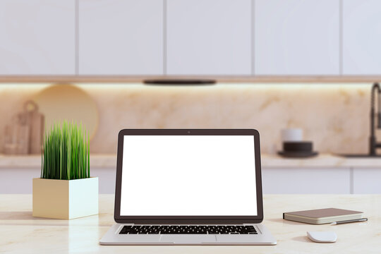 An open laptop with a blank screen on a kitchen counter next to a plant and closed notebook. 3D Rendering