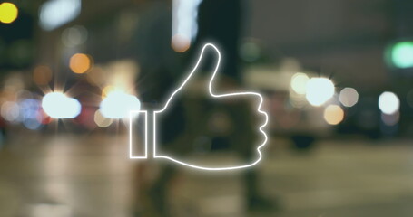 A neon-like thumbs up sign glows against a blurred city backdrop at night