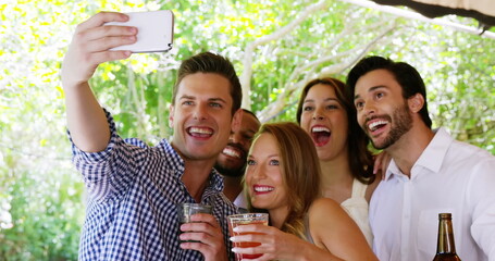 Obraz premium Emoji icons fly as diverse friends take a selfie at a party in 4k.