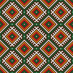 Seamless ethnic pattern in the style of embroidery. The pattern features colorful geometric shapes, including squares, triangles, and diamonds, arranged in rows on a white background. 