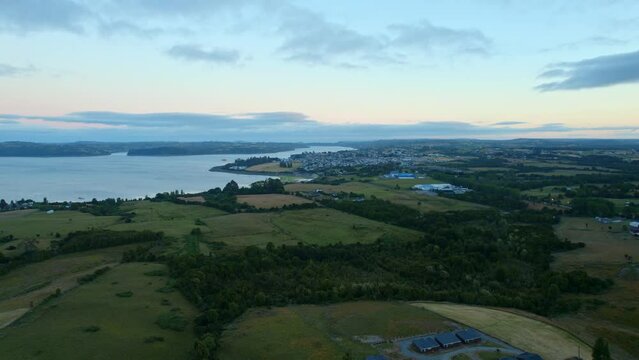 Aerial Drone Above Chilo&eacute; Chilean Patagonian Island Landscape, Chonchi background, environment, nature of South America, blue sea bay with skyline at sunset