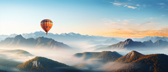 A hot air balloon is flying over foggy mountains high.
