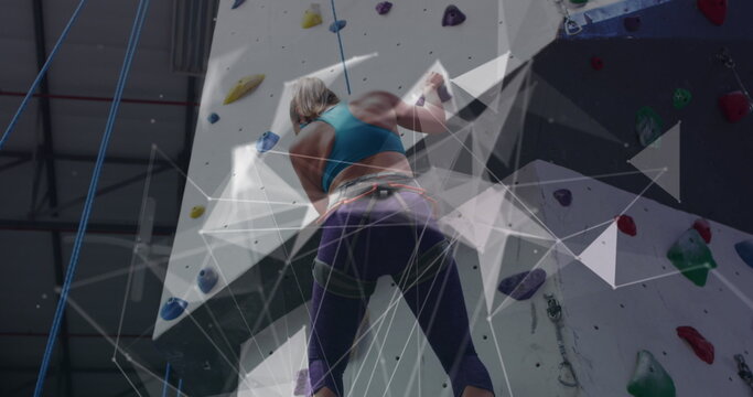 Image of data processing over caucasian woman climbing wall - Powered by Adobe