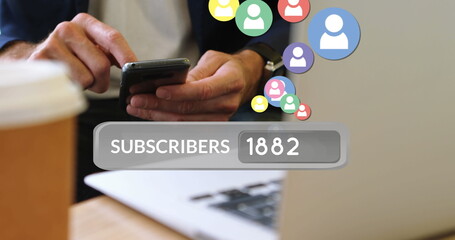 Close up of a businessman seated on a desk in front of a laptop and a cup of coffee while texting
