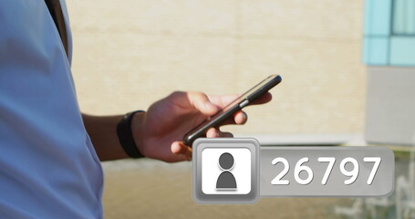 Close up of a man texting on his phone while brisk walking on a sidewalk