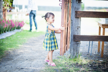 A girl opens the door to a flower garden and welcomes herself into beautiful nature.
