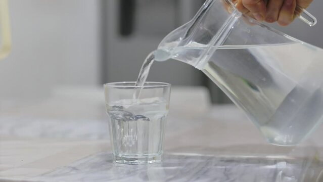Pouring Water into Glass from Jug