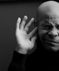 deaf man suffering from deafness and hearing loss on grey background with people stock photo	