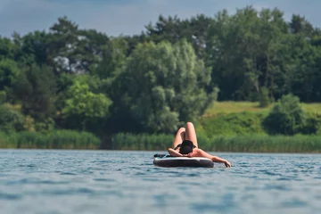 Foto op Canvas woman in swimming suit sunbathing on supboard © phpetrunina14