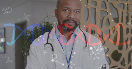Image of dna strand and molecules over smiling african american male doctor in hospital