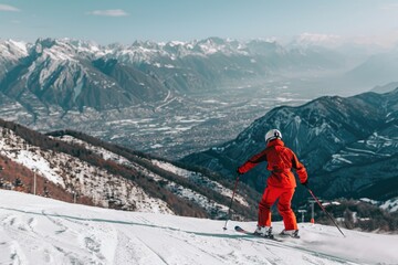 A skier skiing down a snowy slope with mountains in the background.