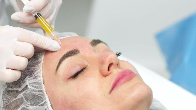 Medical cosmetology of plasma injections. Cosmetology, facial injections close-up. A professional cosmetologist, doctor does mesotherapy, plasma therapy to a young woman.