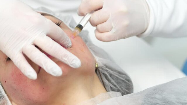 Medical cosmetology of plasma injections. Cosmetology, facial injections close-up. A professional cosmetologist, doctor does mesotherapy, plasma therapy to a young woman.