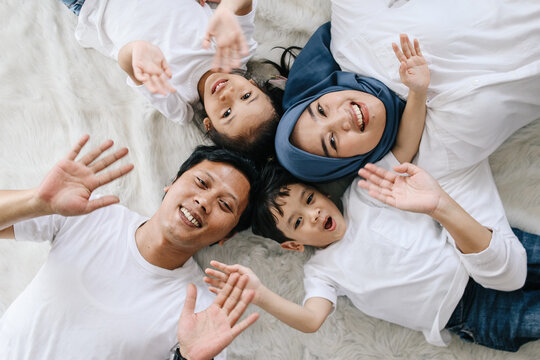 Top view portrait of happy Asian family lying on the floor at home