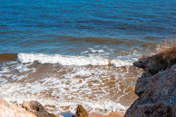 Seascape. Blue sea with waves on a rocky coast. The shore of the Sea of Azov in Crimea