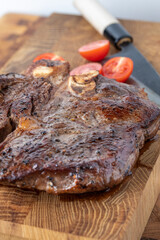 A steak on a cutting board with herbs and spices.Grilled beef tenderloin steak on a wooden board with grilled vegetables. Filet Mignon recipe concept, selective focus