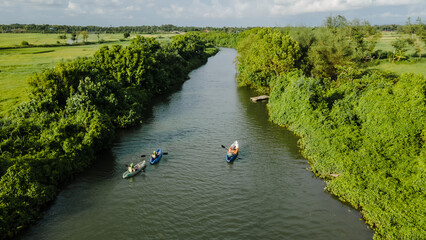 aerial view, you can see a person rowing in a canoe at the mouth of the river.