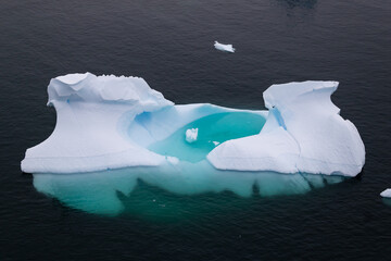 Iceberg avec piscine gelée et mini iceberg en son centre en Antarctique