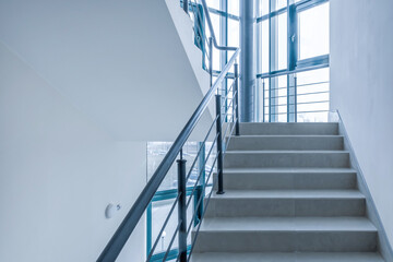 stairs emergency and evacuation exit stair in up ladder in a new office building in blue color grading toning