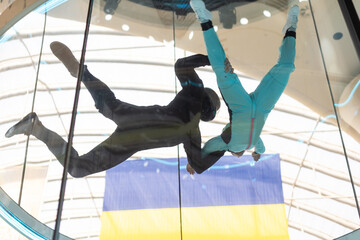 A teenage girl and an instructor climb up in an air tube