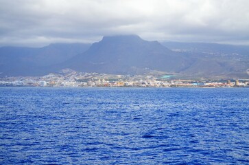 Fototapeta premium View on resorts and beaches of South coast of Tenerife island during sail boat trip along coastline, Canary islands, Spain in winter