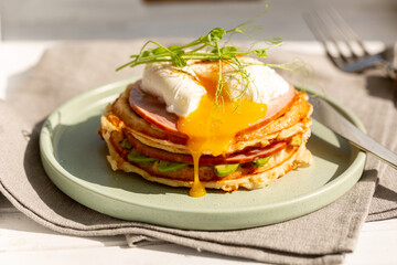 Breakfast of cheese waffles with ham and poached egg