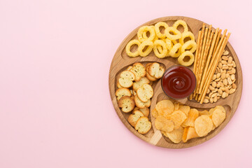 Different tasty snacks with sauce on color background, top view