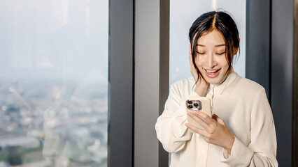 Portrait of Young asian businesswoman happy excited joyful celebrating Success on Smartphone in...