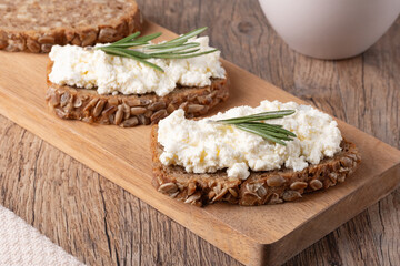 Home made rye bread on a wooden cutting board with curd cheese