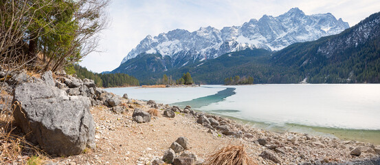 frozen lake Eibsee with small channel. view to Zugspitze mountain mass. bavarian landscape