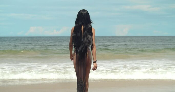 Adorned in an anime cosplay bikini, a girl relishes the tranquility of the white sand beach on Trinidad, a Caribbean gem.