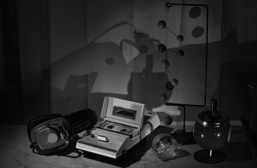 vintage cassette tape recorder and old headphone in a seventies objects arrangement.Black and white image.