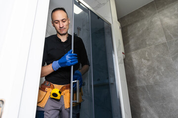 Plumber installing a shower cabin in bathroom