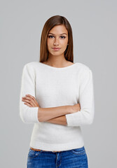 Portrait, arms crossed and woman in studio for fashion isolated on a white background. Confidence, young person and serious model in casual clothes, jeans or trendy style on backdrop in Argentina