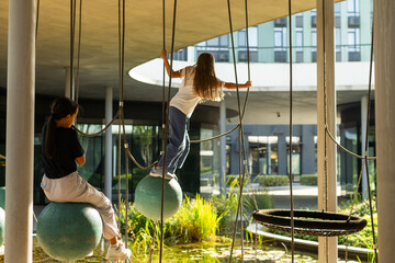 A young girl enjoys the pole ride at the playground runaway, on a warm day.