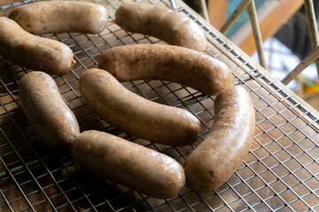 putting cured sausage link on cooling rack  to dry the natural casing and curing process, smoking...