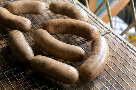 putting cured sausage link on cooling rack  to dry the natural casing and curing process, smoking meat process
