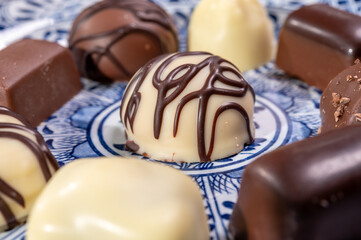 Variety of luxury belgian chocolate pralines bonbons on blue china porcelain plate, tea time