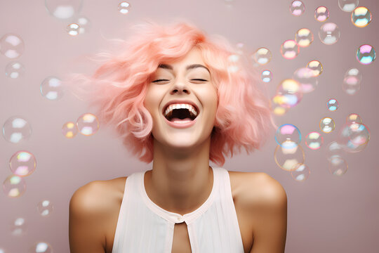 Closeup portrait of happy smiling young woman with pink hair and soap bubbles