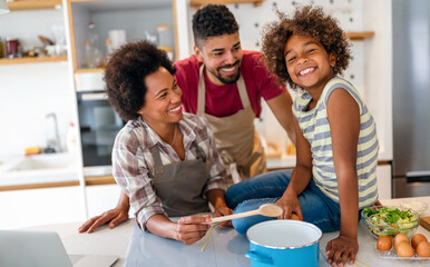 Overjoyed young african american family with kid have fun cooking at home together,