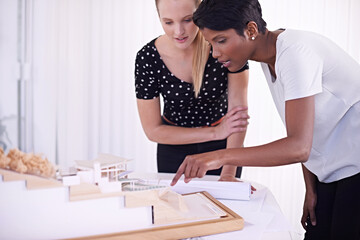 Model, floor plan or people with engineering teamwork for development project or planning on paper. Architecture, women or group of designers talking in collaboration for blueprint of office building