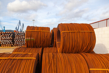 An open-air warehouse with twisted spools of rusty wire.