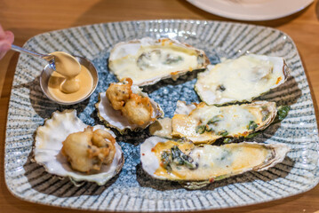 Plate with baked oysters on a table in a restaurant