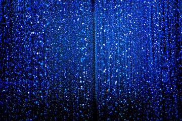 Celebration lights at Christmas New Year festival. Crowd of hanging blue light bulbs blue bokeh background. blue light bulb tunnel. 